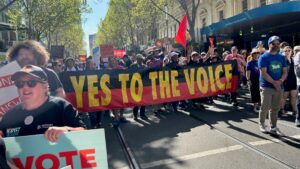 people marching with large banner "Yes to the Voice"
