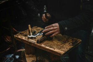 image of a man's hands with woodwork cutting tools