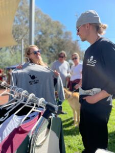 Person showing a Degrowth Network sweater to visitor wearing a Sea Shepherd T.shirt at festival